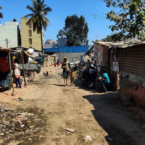 People walk through an informal settlement for trash segregators in Bangalore, India.