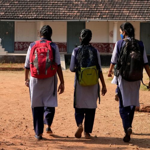 Indian students in uniform clothing arrive at a government-run junior school in Udupi, Karnataka state, India, Feb. 24, 2022.