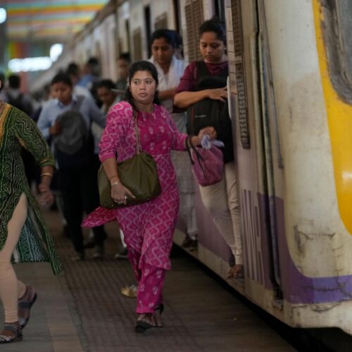 Women rush out of a train during peak hours at Churchgate station in Mumbai, India, Monday, March 20, 2023.